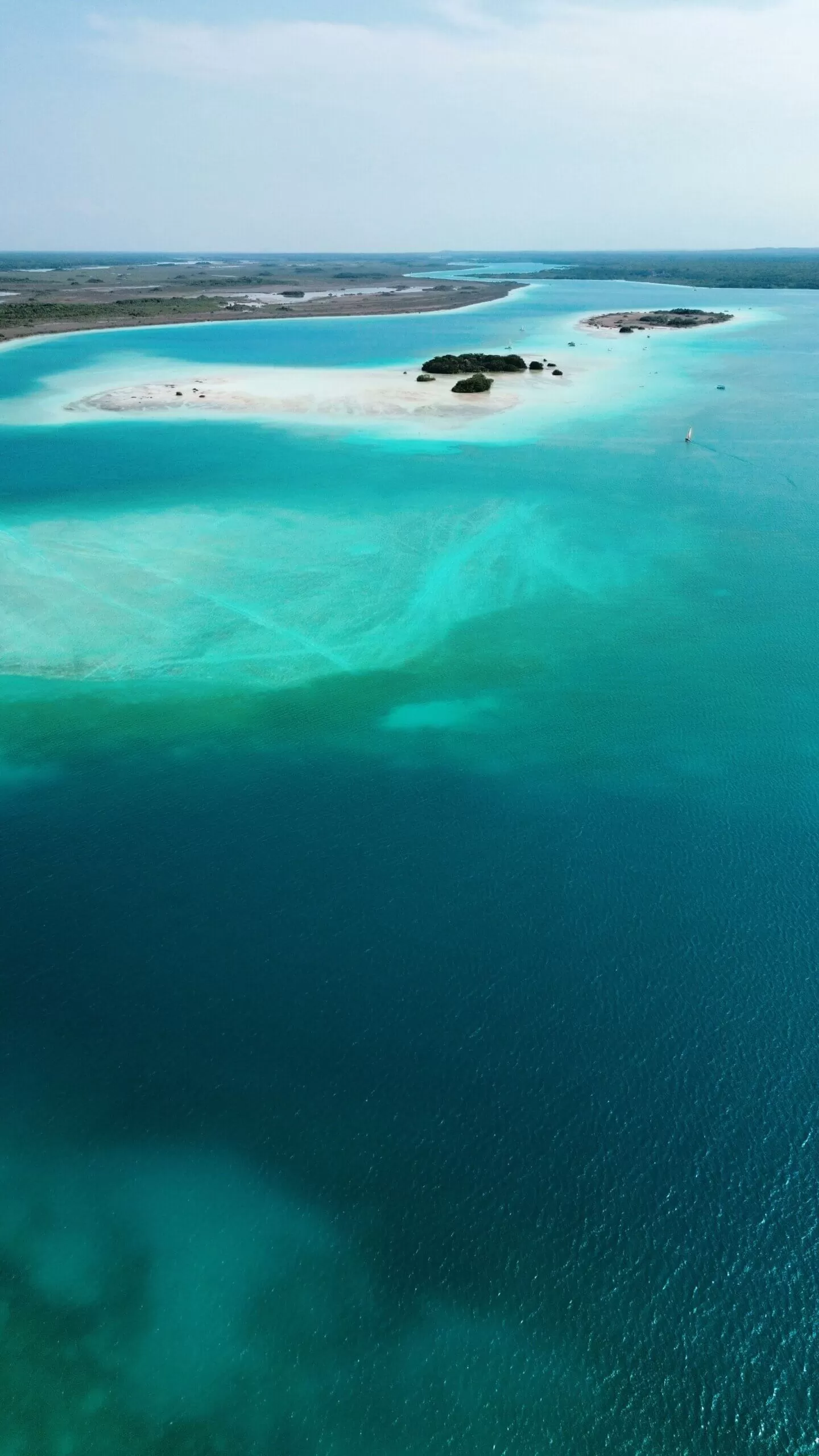 laguna bacalar vista desde drone. se ven en la laguna muchos tonos de azules y celestes