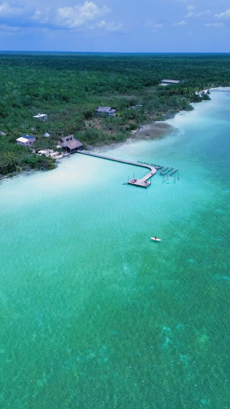 foto desde el drone de la laguna nopalitos. se ve la laguna con el agua turquesa y el parador "Neek" en la orilla con un muelle hacia la laguna