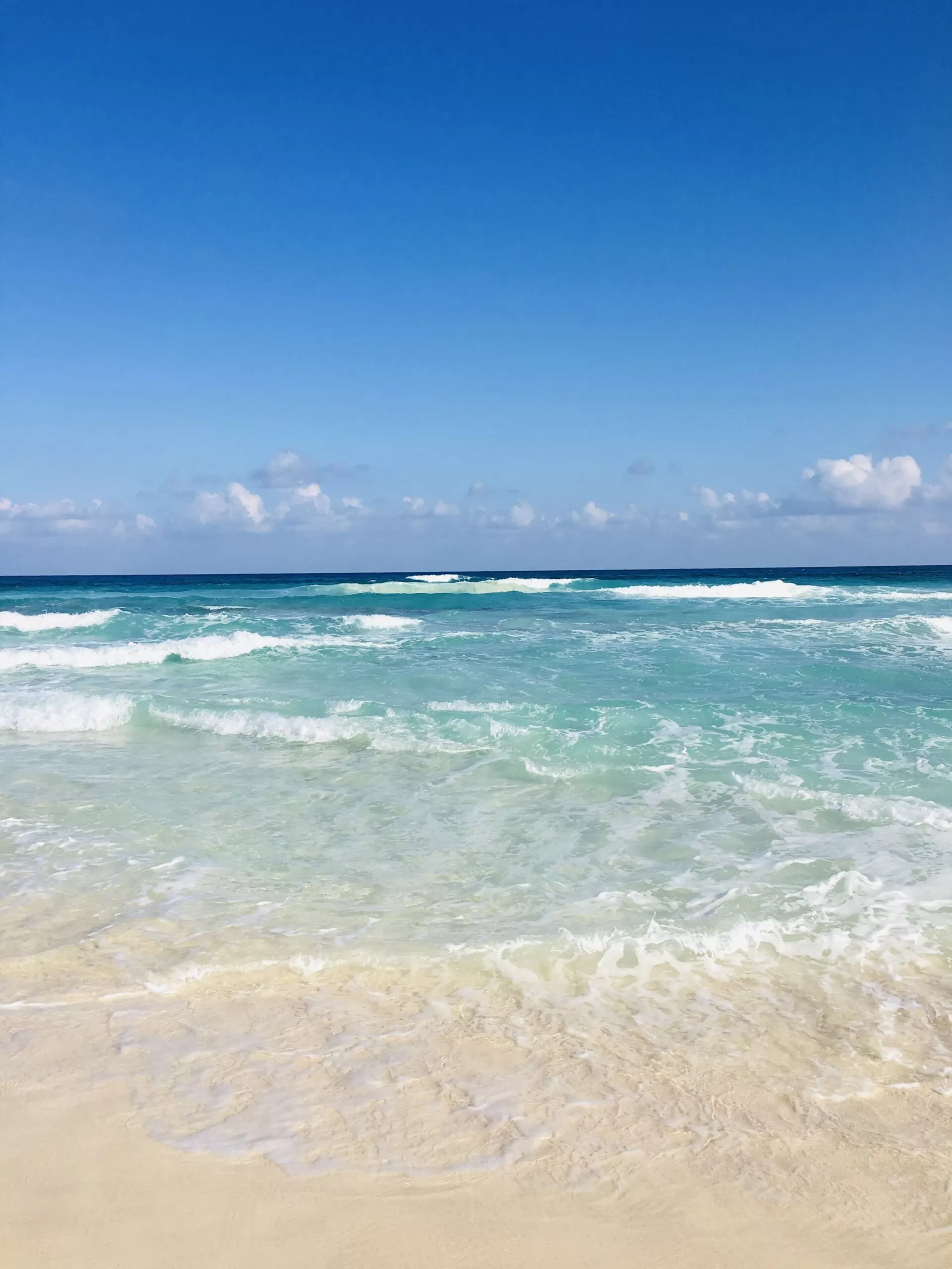 foto tomada en la playa de cozumel. se ve el inicio del mar. las olas y el horizonte