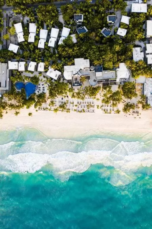 la foto pertenece al Hotel Casa Malca. es una foto tomada con drone. se puede ver un poco el mar y el hotel sobre la orilla con selva atras.