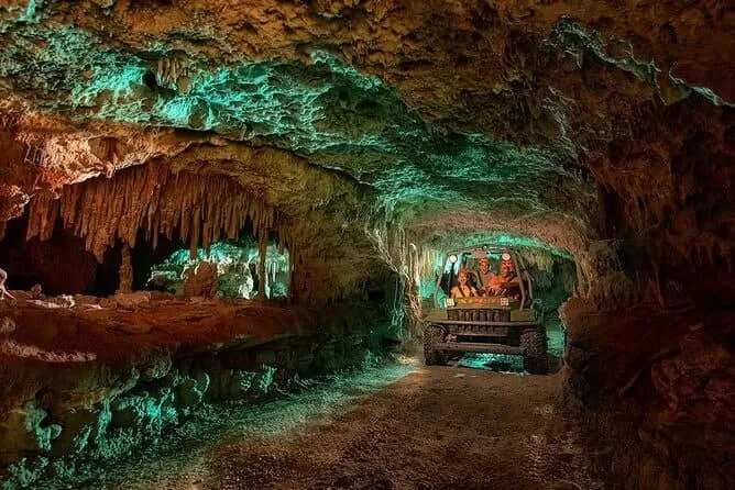 parque xplor en playa del carmen. se ve una familia en un auto recorriendo una especie de caverna con estalactitas