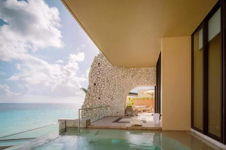 foto del hotel La Casa de la Playa by Xcaret. se ve el balcon de una habitacion con una pileta que da al mar