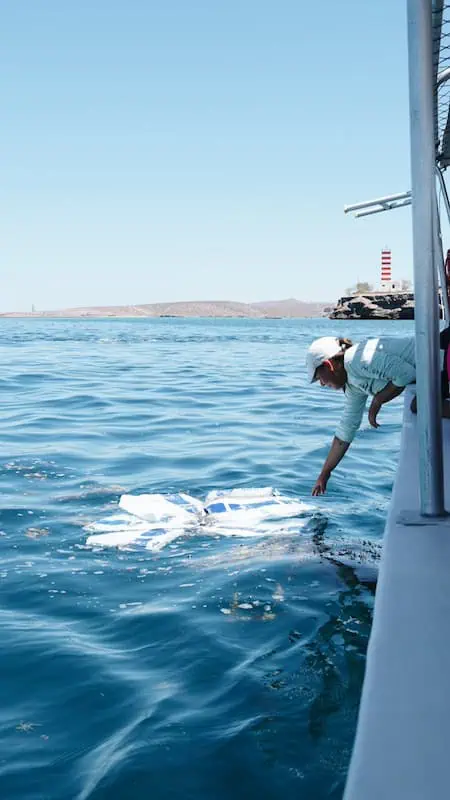 la guia de la excursion de la isla espiritu santo recogiendo basura del mar