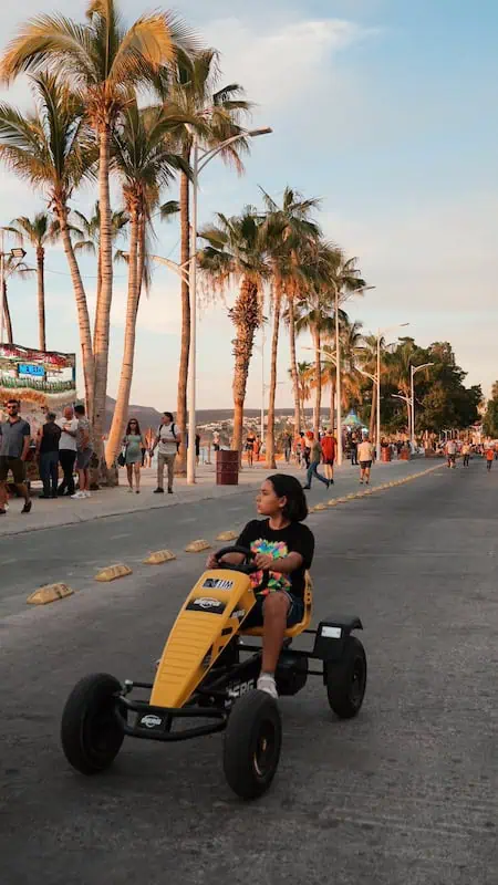 niña andando en un auto para niños en el malecon de la paz bcs