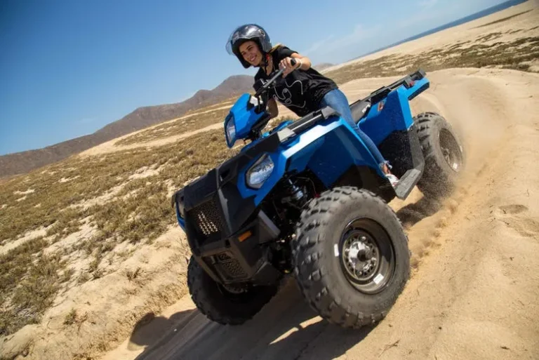 Grupo de personas en quads, recorriendo senderos naturales y playas remotas, disfrutando de una aventura al aire libre en Los Cabos.