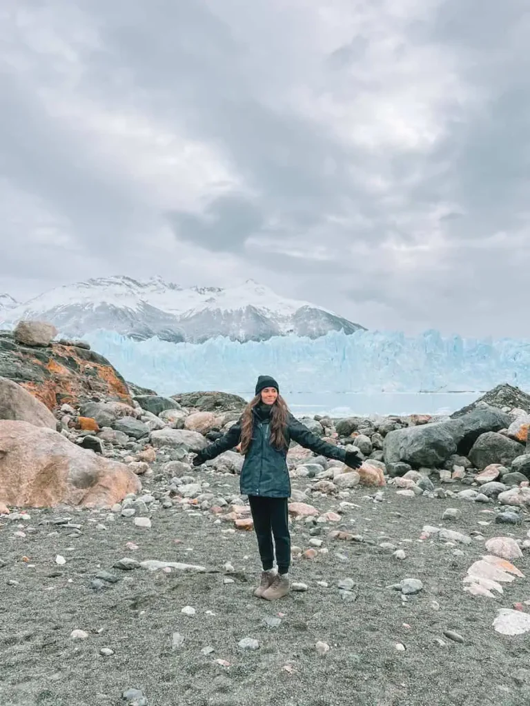 pau con los brazos abiertos y de fondo el glaciar perito moreno