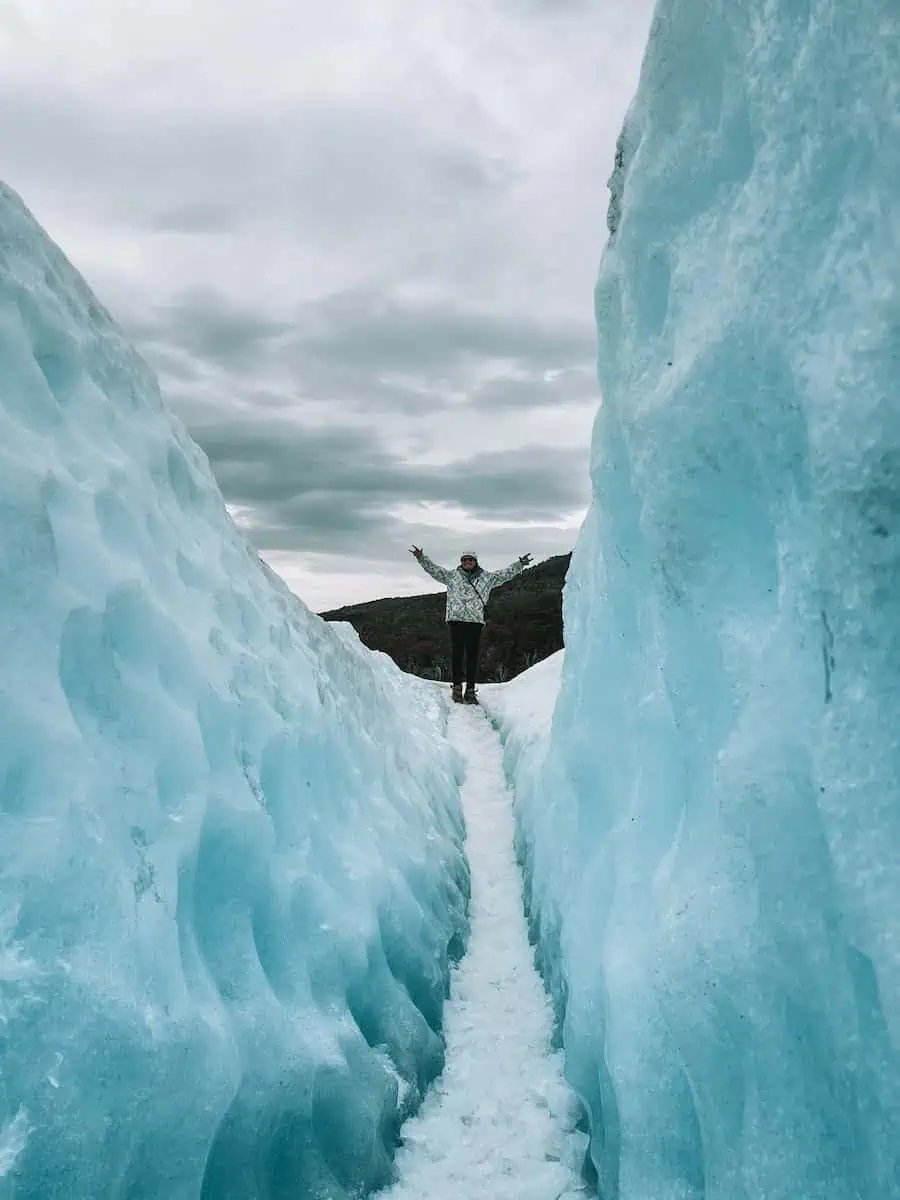 el novio de pau a lo lejos con los brazos abiertos en el medio del glaciar