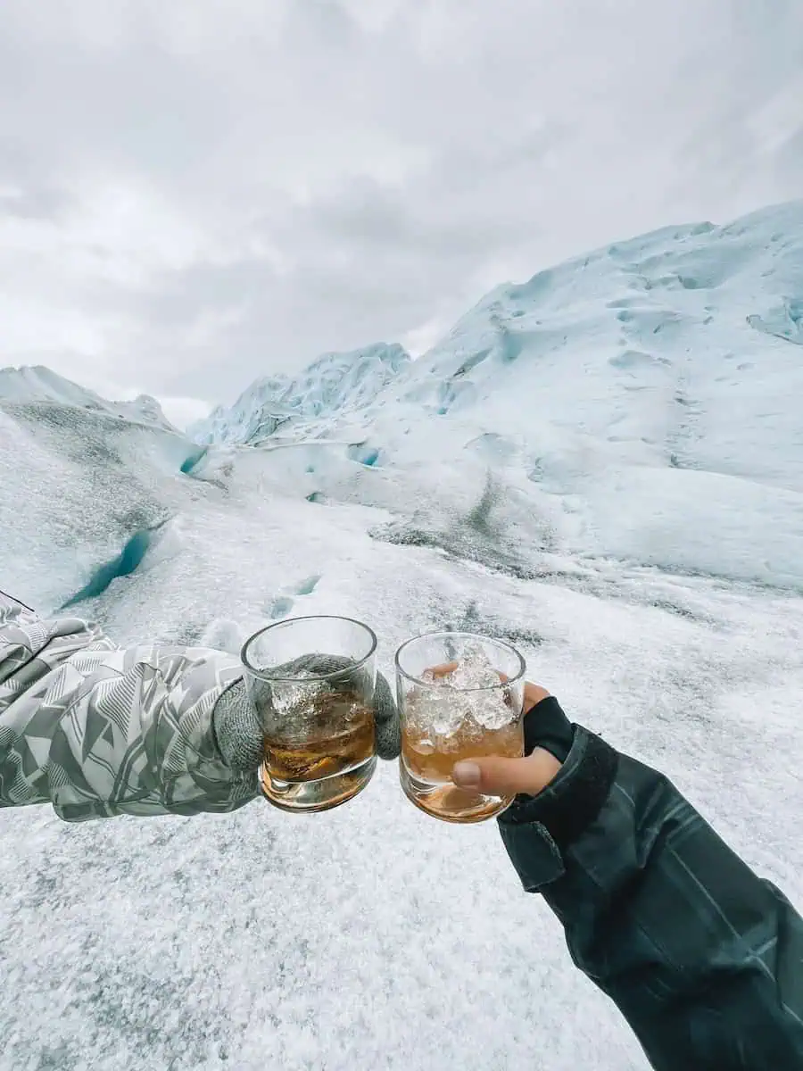 chin chin con dos vasos de whisky en el medio del glaciar